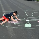 Jason McDonald, a Lemoore High student, puts some finishing touches on his street artwork.